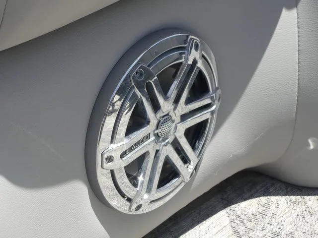 Slide: The Image of A speaker with a shiny metal grille is embedded in the gray upholstery of a boat. - 42