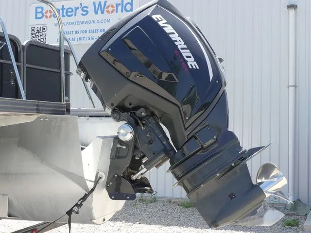 Slide: The Image of An Evinrude outboard motor is mounted on a Manitou Encore 25 SR SHP boat, resting on gravel. - 7