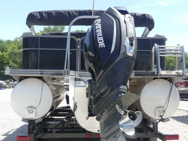 Slide: The Image of A 2019 Manitou Encore 25 SR SHP pontoon boat with an Evinrude outboard motor, on a trailer. - 6