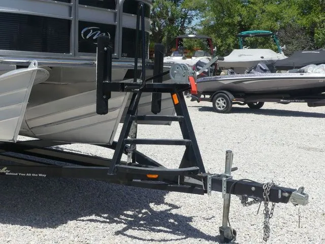 Slide: The Image of A 2019 Manitou Encore 25 SR SHP on a trailer, surrounded by other boats. - 14