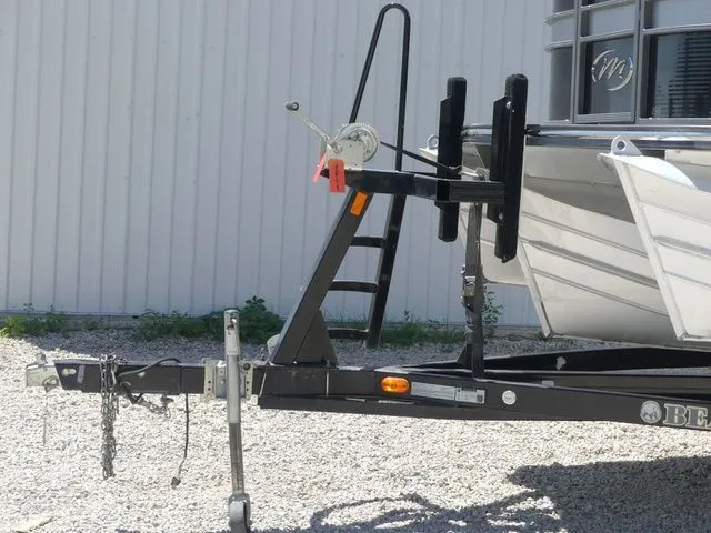Slide: The Image of A boat trailer with a winch and supports holding a boat. The background is a building. - 13