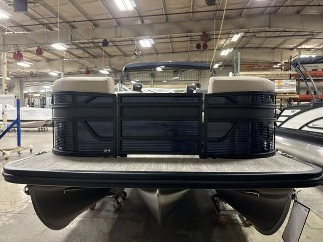 Slide: The Image of A Bennington pontoon boat in a warehouse, featuring a spacious deck and comfortable bench seating. - 3