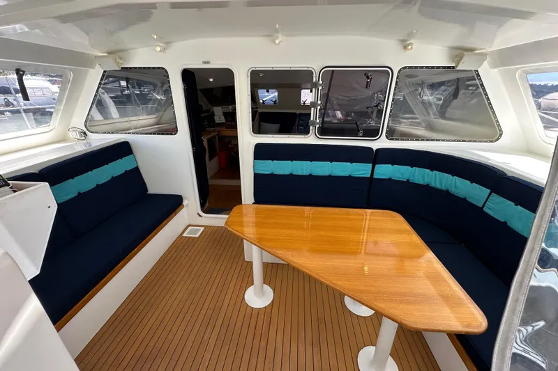 Slide: The Image of Spacious interior of 1999 Baltec Engineering Visiona Catamaran with wooden table and cushioned seating. - 17