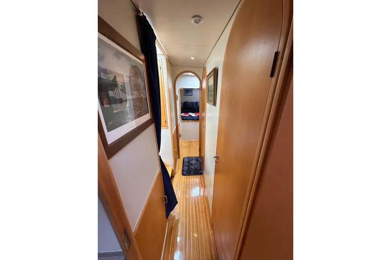 Slide: The Image of Interior hallway of 1999 Baltec Engineering Visiona Catamaran, featuring wooden doors and framed artwork. - 35