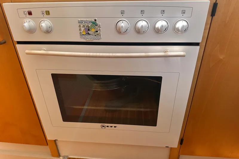 Slide: The Image of White Neff oven with control knobs, set in wooden cabinetry on a 1999 Baltec Engineering Visiona Catamaran. - 67