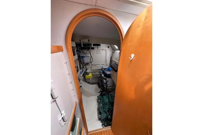Slide: The Image of Engine room of 1999 Baltec Engineering Visiona Catamaran, featuring equipment and wooden door. - 53