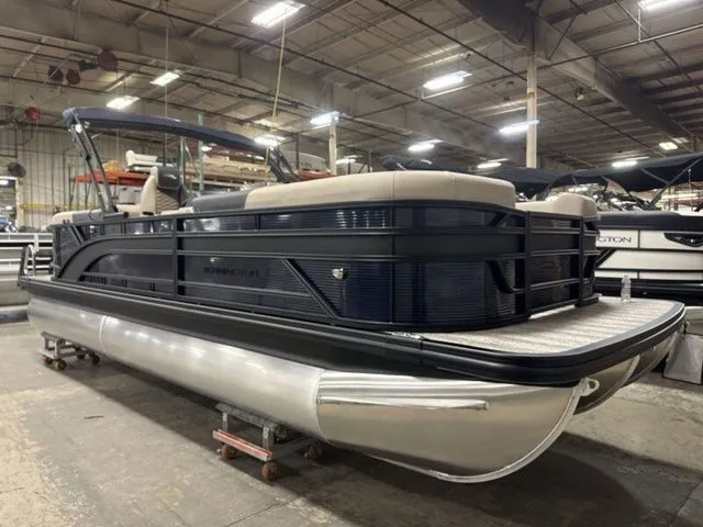 The Image of A 2026 Bennington S Quad Bench 23 SSR pontoon boat is in a warehouse. - 1