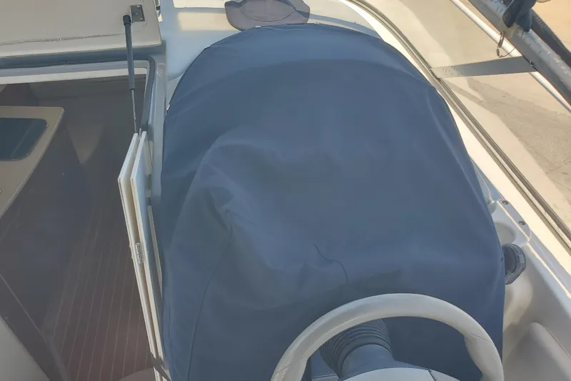 Slide: The Image of 2004 Bayliner 285 boat helm covered, showcasing steering wheel and cockpit area. - 16