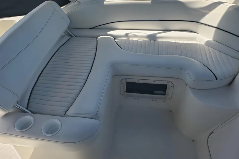 Slide: The Image of 2004 Bayliner 285 boat interior with white cushioned seating and cup holders. - 20
