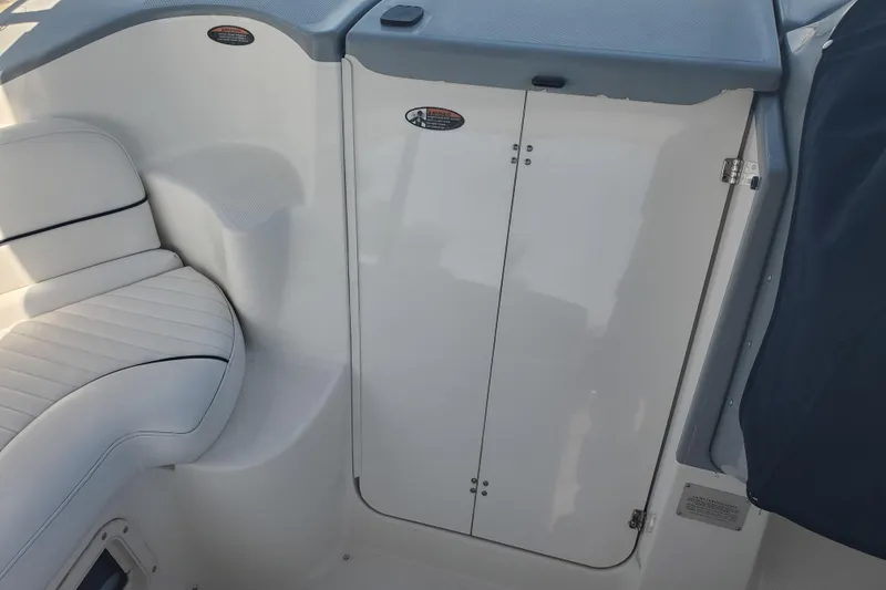 Slide: The Image of 2004 Bayliner 285 boat interior with white seating and storage compartment. - 19