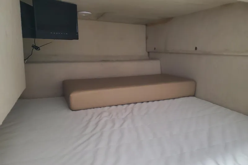 Slide: The Image of Interior cabin of a 2004 Bayliner 285 boat with a bed and TV. - 12