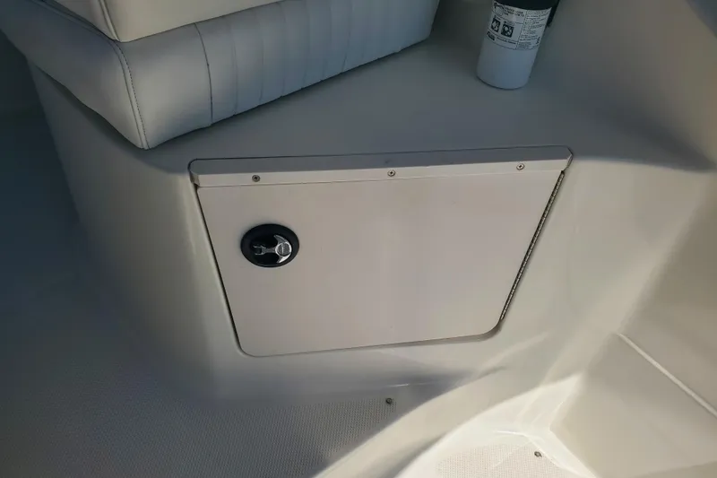 Slide: The Image of 2004 Bayliner 285 boat interior storage compartment with white seating and safety equipment. - 25