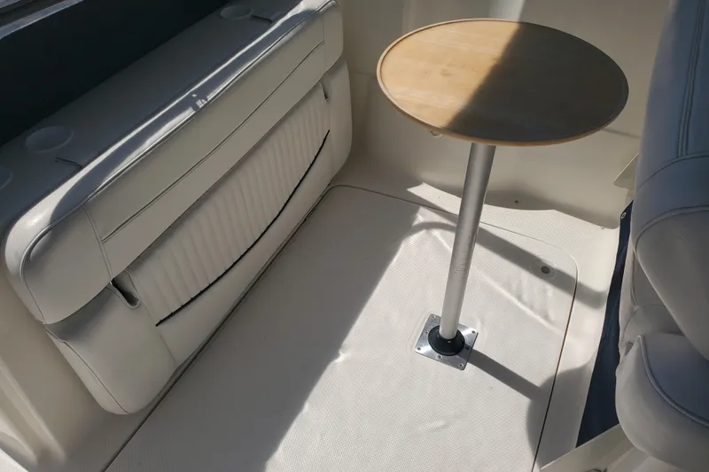 Slide: The Image of Interior of a 2004 Bayliner 285 boat with seating and a small round table. - 22