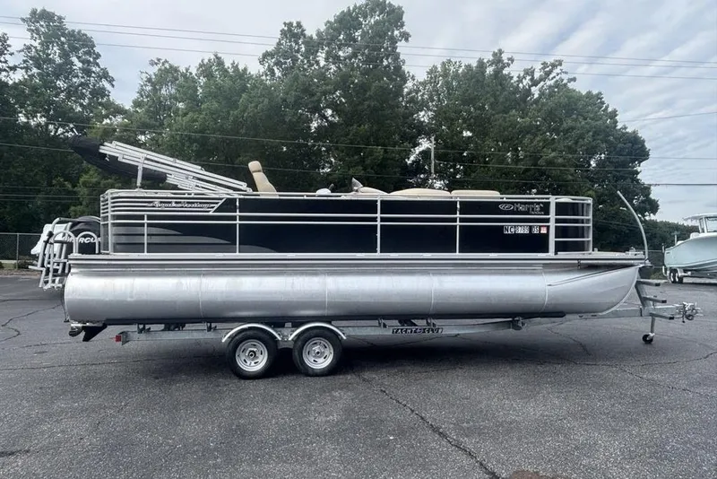 The Image of 2011 Harris Royal Heritage 260 I/O pontoon boat on trailer, parked outdoors. - 1