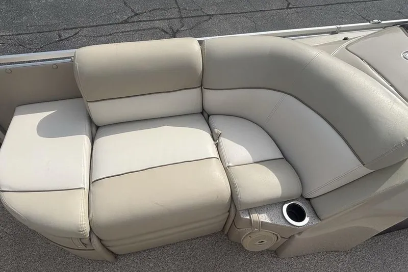 Slide: The Image of Luxurious seating on 2011 Harris Royal Heritage 260 I/O boat, featuring beige upholstery and cup holder. - 10