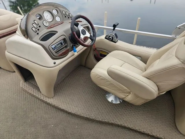 Slide: The Image of The image shows the cockpit of a 2008 Tracker Regency Party Barge with beige seating and dashboard. - 24