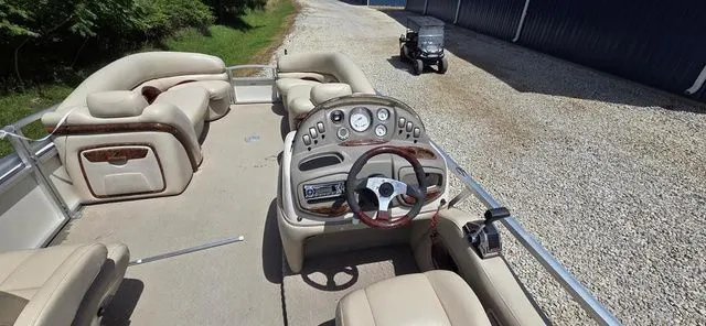 Slide: The Image of The image shows the cockpit of a 2008 Tracker Regency Party Barge with beige seating. - 10