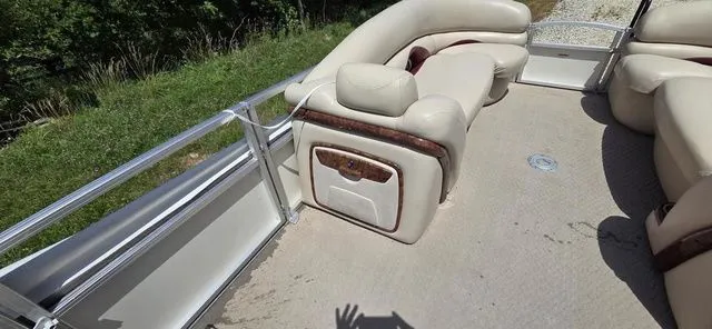 Slide: The Image of A 2008 Tracker Regency Party Barge with beige upholstery and metal railings, on a trailer. - 16