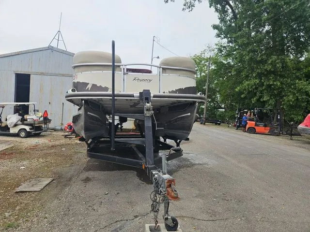 Slide: The Image of A 2008 Tracker Regency Party Barge on a trailer, parked on a gravel lot next to a building. - 20