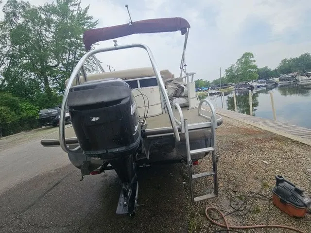 Slide: The Image of A 2008 Tracker Regency Party Barge with an outboard motor, parked by a calm lakeside. - 23