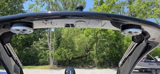 Slide: The Image of A boat with a black Bimini top and speakers, surrounded by trees. - 16