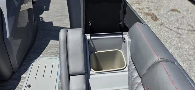 Slide: The Image of The image shows the interior of a Bennington 25 RXSBA boat with gray upholstery and a storage compartment. - 19