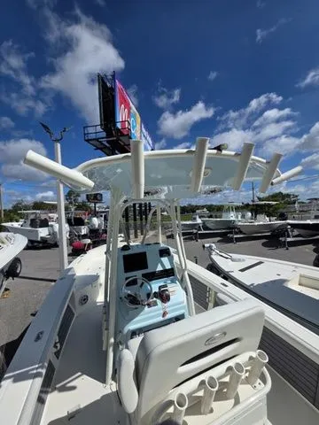 Slide: The Image of Pathfinder 2400 TRS 2023 with T-top and fishing rod holders, parked under a blue sky. - 5