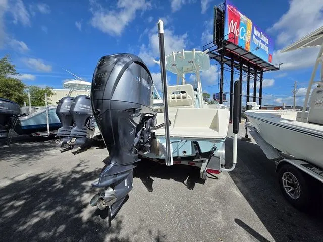 Slide: The Image of A 2023 Pathfinder 2400 TRS with a powerful outboard motor, parked in a sunny lot. - 2