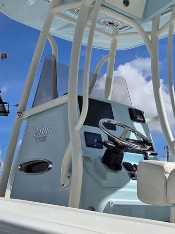Slide: The Image of The image shows the helm of a 2023 Pathfinder 2400 TRS boat with a blue sky background. - 10