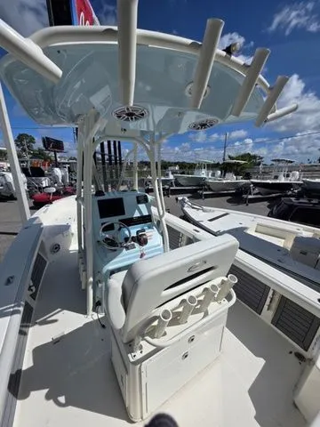 Slide: The Image of Pathfinder 2400 TRS 2023 with center console, helm station, and fishing rod holders outdoors. - 9