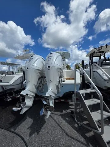Slide: The Image of Two powerful outboard engines on a Cobia 265CC boat, surrounded by other boats under a cloudy sky. - 3