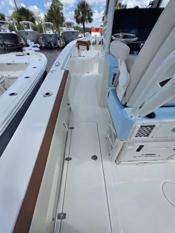 Slide: The Image of The image shows the deck of a 2027 Cobia 265CC boat with white and blue accents. - 18