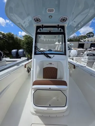 Slide: The Image of The image shows the cockpit of a 2027 Cobia 265CC boat with brown upholstery. - 23
