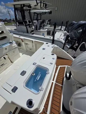 Slide: The Image of The image shows a modern Cobia 265CC boat with a spacious deck and two outboard engines. - 5
