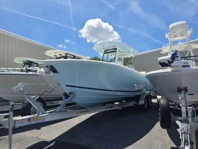 The Image of Cobia 265CC 2027 on a trailer between other boats outdoors. - 1