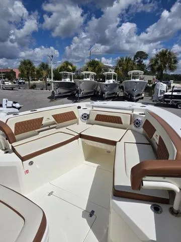 Slide: The Image of The image shows the cockpit of a Cobia 265CC boat with beige and brown upholstery. - 25