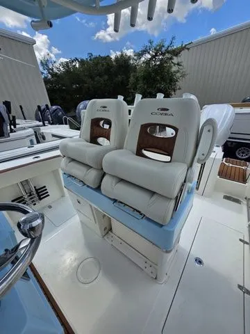 Slide: The Image of The 2027 Cobia 265CC features two cushioned seats with wood accents and a helm station. - 12