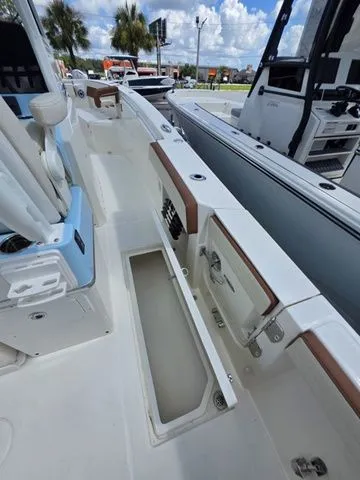 Slide: The Image of The image shows the deck of a Cobia 265CC boat with storage and seating. - 19