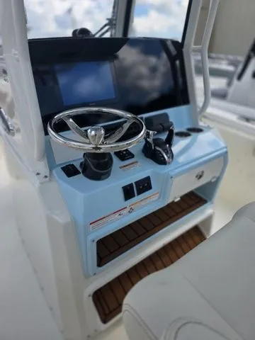 Slide: The Image of The image shows the helm of a Cobia 265CC boat with a modern steering wheel and controls. - 16