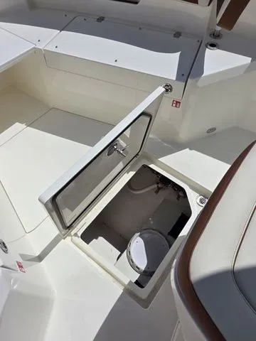 Slide: The Image of An open storage compartment on a 2027 Cobia 265CC boat. - 26