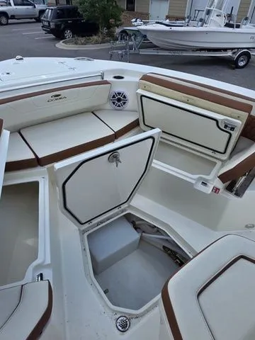 Slide: The Image of The image shows the cockpit of a Cobia 245CC boat with white and brown upholstery. - 25