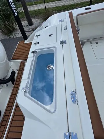 Slide: The Image of The image shows the deck of a Cobia 245CC boat with a built-in storage compartment. - 6