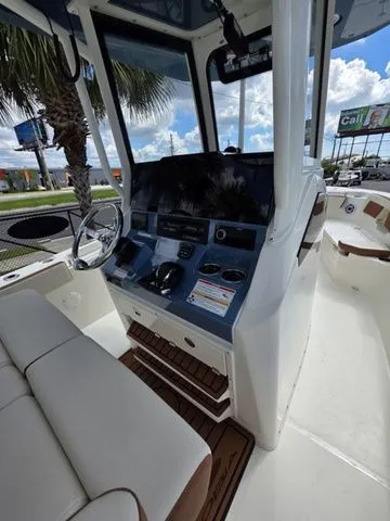 Slide: The Image of The image shows the cockpit of a 2027 Cobia 245CC boat with modern controls. - 16