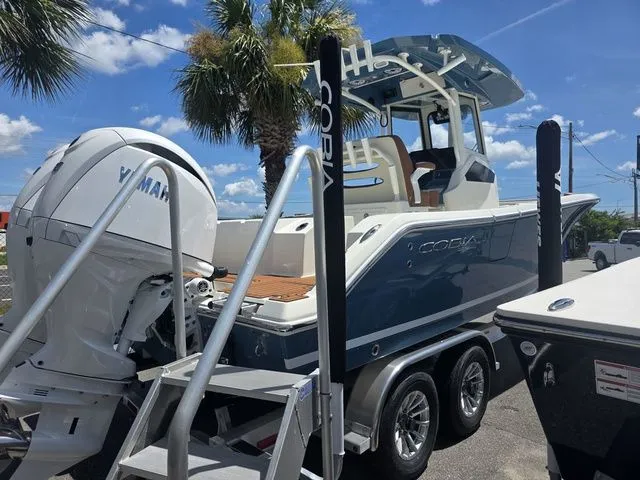 Slide: The Image of A 2027 Cobia 245CC boat on a trailer. It features a large outboard motor. - 3