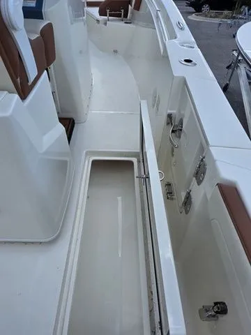 Slide: The Image of The image shows the deck of a Cobia 245CC boat with an open storage compartment. - 14
