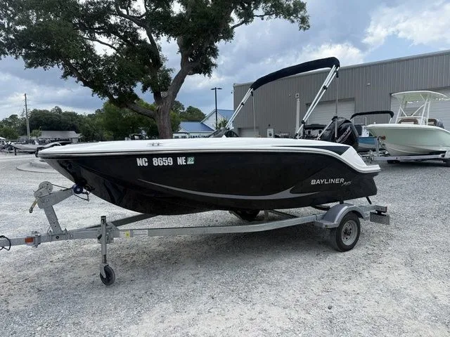 The Image of A 2025 Bayliner M15 sits on a trailer in a gravel lot. - 1