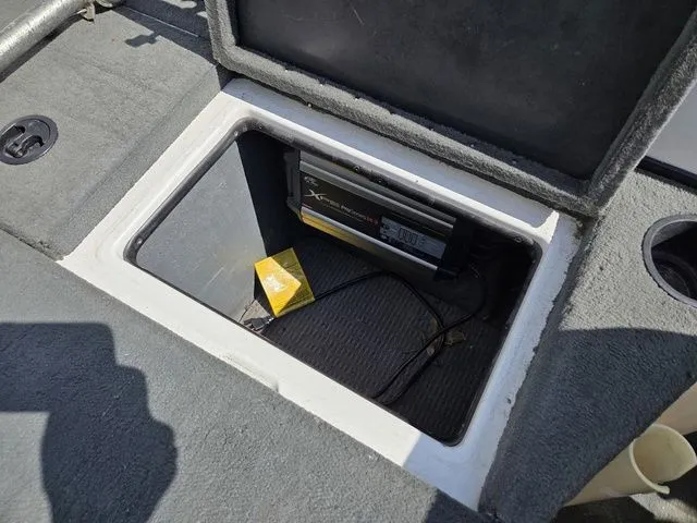 Slide: The Image of An open storage compartment on a boat with a charger and a yellow package. - 12