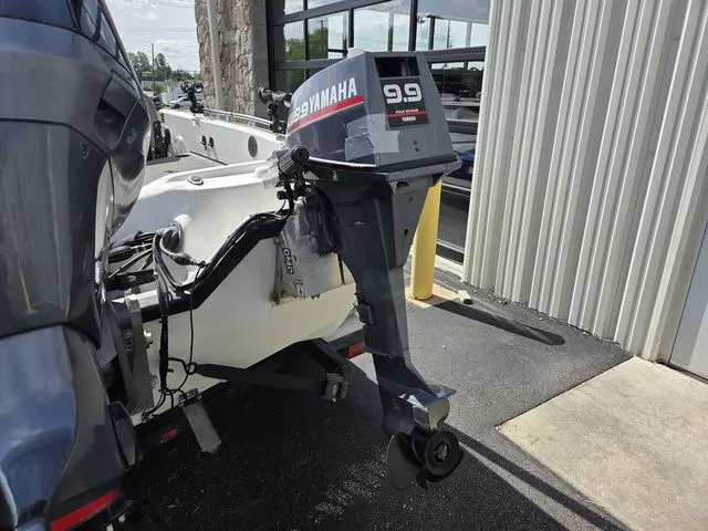 Slide: The Image of A 2003 Stratos 21 MSX with a Yamaha 9.9 outboard motor, parked beside a building. - 8
