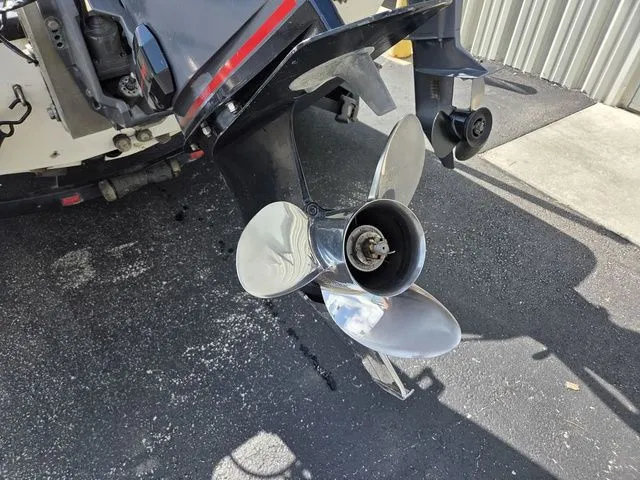 Slide: The Image of A shiny propeller on a 2003 Stratos 21 MSX boat, set against an asphalt surface. - 7