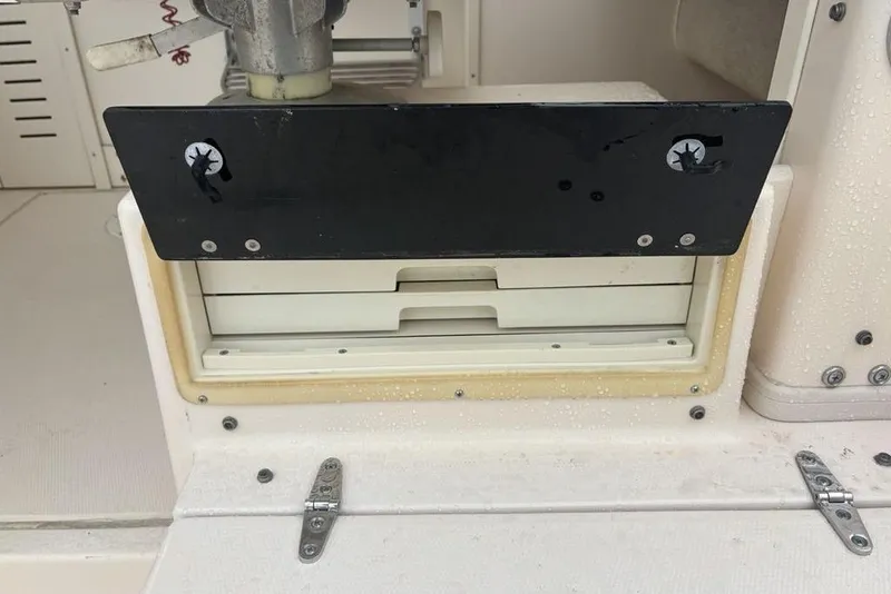 Slide: The Image of 1999 Grady-White Gulfstream 232 boat compartment with black panel and hinges. - 36